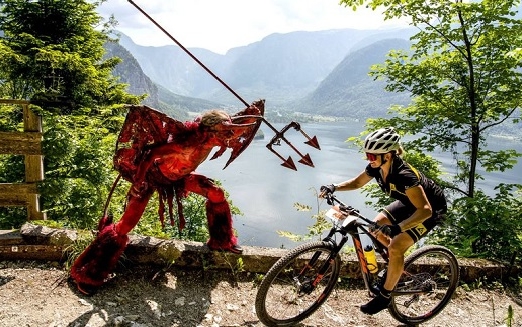 Mountainbikerin mit einem als Teufel verkleideten Mann